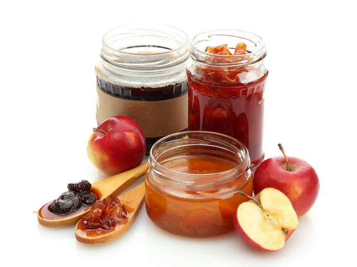 Jars of jam with apples and spoons