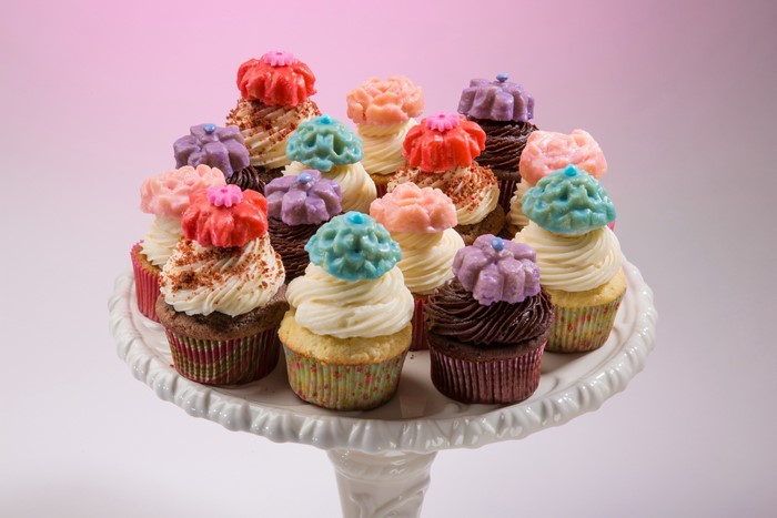 Assortment of colorful cupcakes on a white cake stand