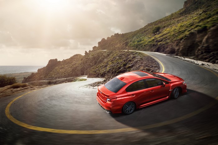 Red Subaru WRX on a winding mountain road