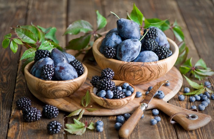 Plums, Blackberries, and Blueberries in wooden bowls