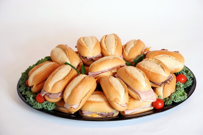Platter of assorted mini sandwiches with tomatoes and lettuce