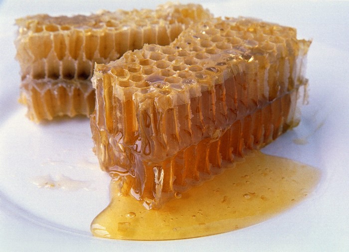 Honeycomb with honey on a white plate