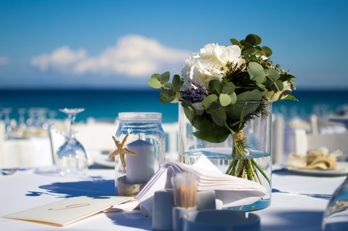 Beach wedding table setting with flowers and sea view