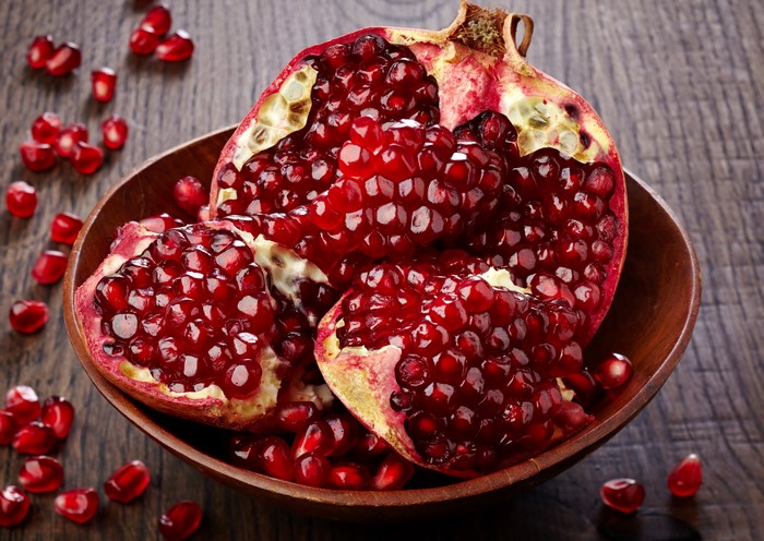 Pomegranate seeds in a wooden bowl