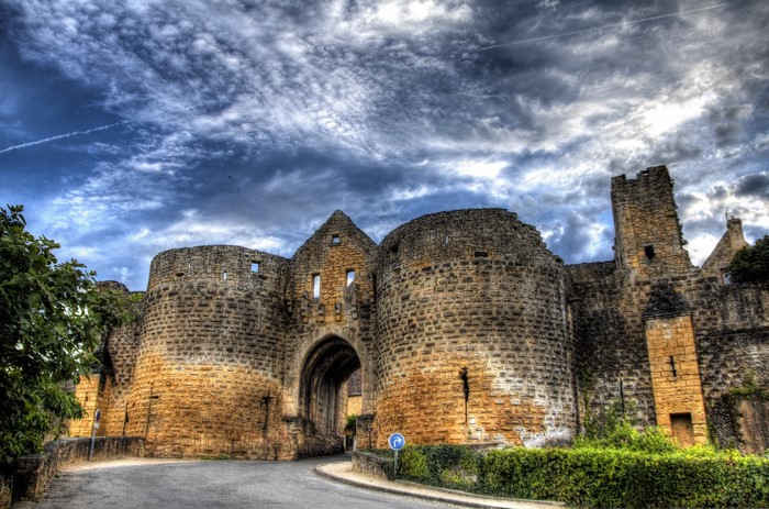 Domme Fortress entrance, France, under a dramatic sky