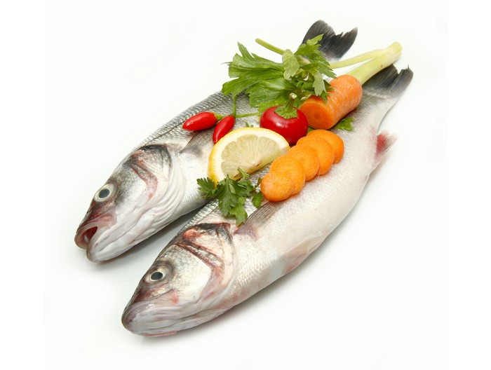 Two raw sea bass with vegetables and lemon