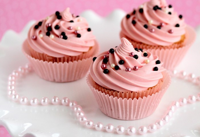 Pink frosted cupcakes with sprinkles and pearls