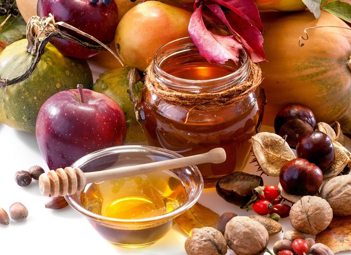 Autumn harvest with apples, pumpkins, honey, and nuts