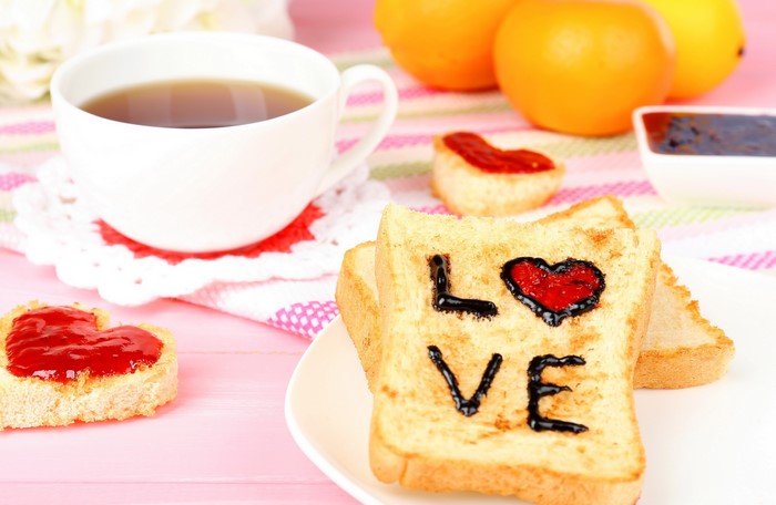 Toast with jam and chocolate spread, cup of tea, and oranges