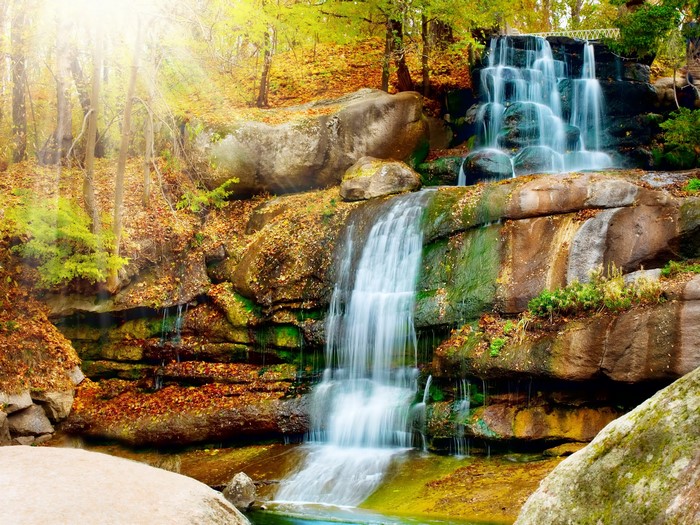 Waterfall cascading over rocks in autumn forest