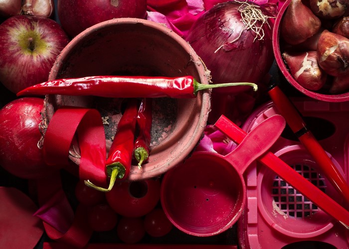 Red still life with chili peppers, apples, and onion