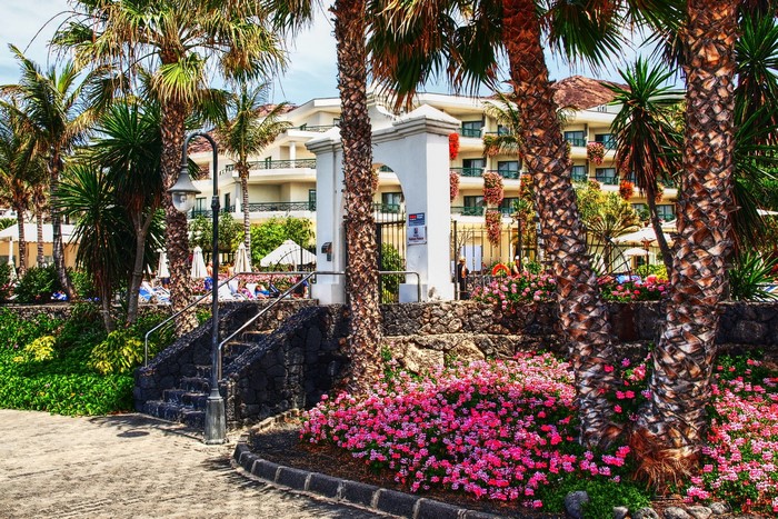 Resort with palm trees and flowers in Playa Blanca, Spain