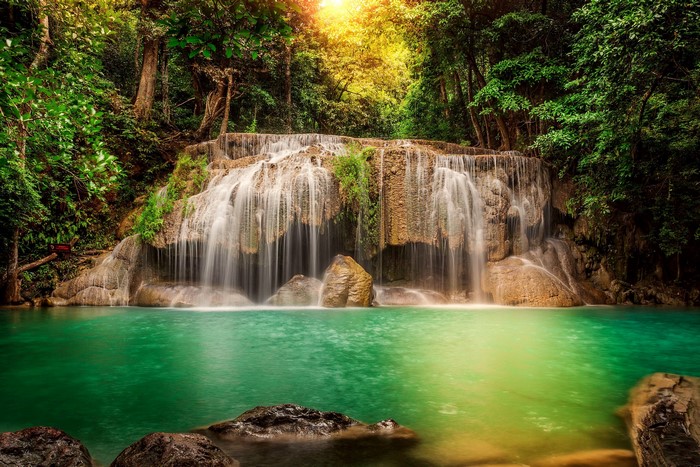 Waterfall in a lush green forest with turquoise water