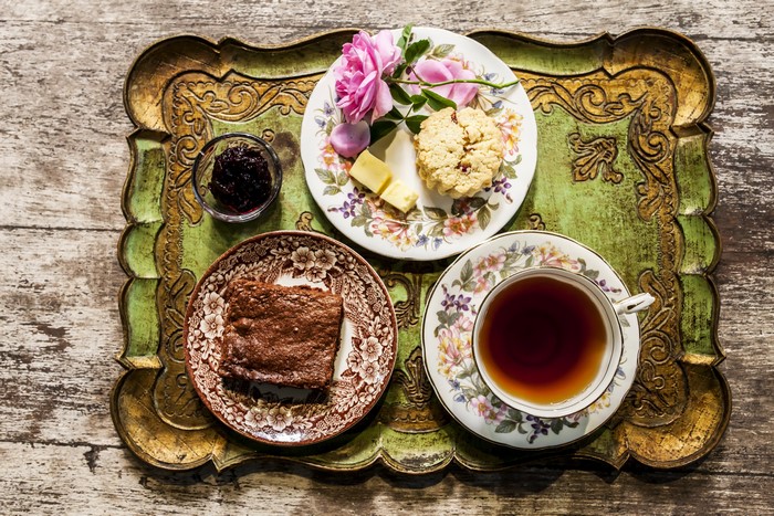 Tea and pastries on a tray with roses