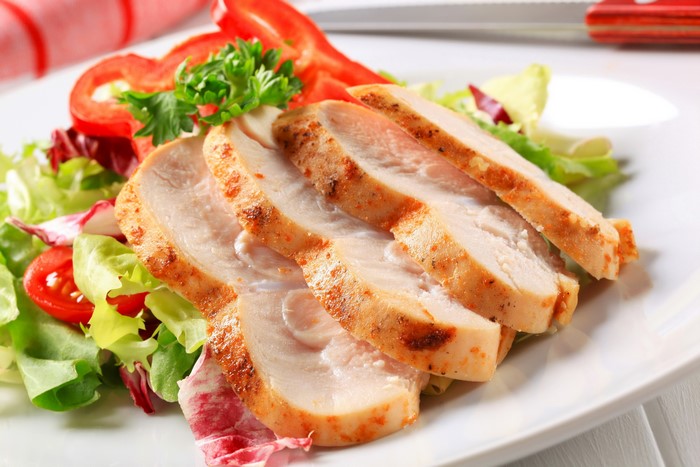 Sliced chicken breast with salad and red pepper