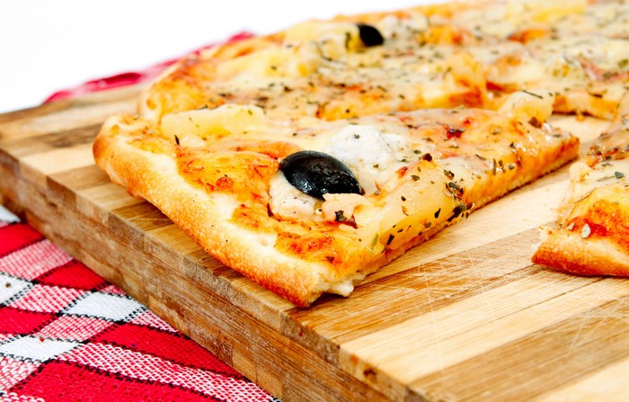 Pizza with olives on a wooden board