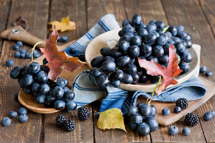 Black Grapes and Berries on Wooden Table