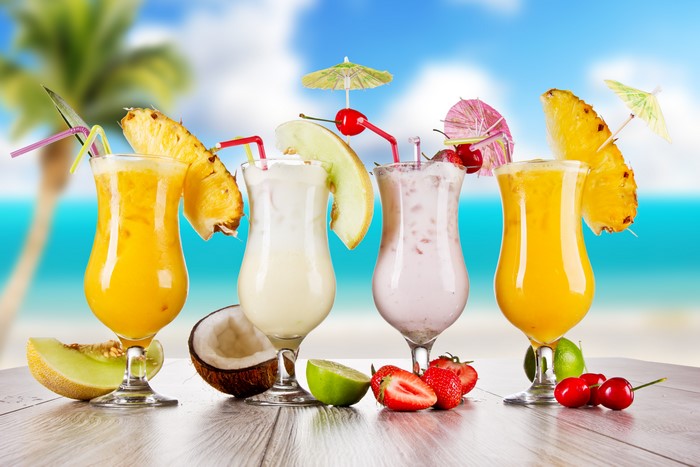 Four tropical cocktails on a beach background