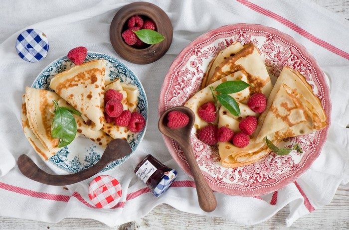 Pancakes with raspberries and jam on plates
