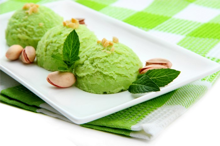 Pistachio ice cream scoops with pistachios and mint