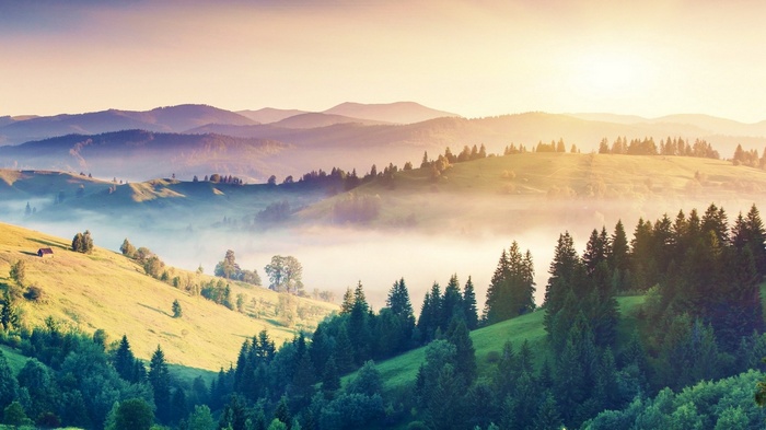 Misty mountains and rolling hills at sunrise
