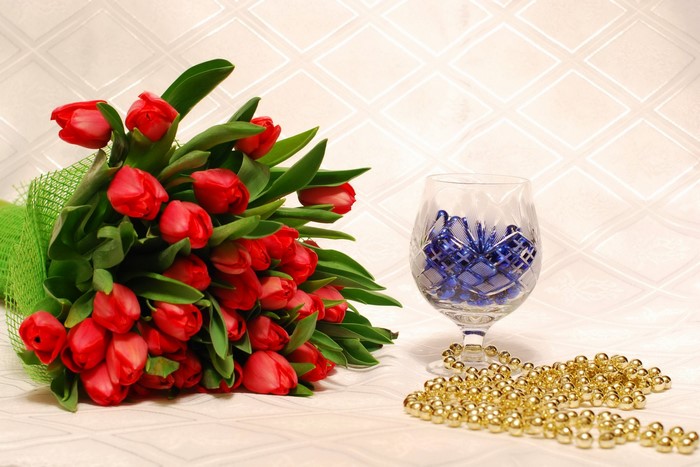 Red Tulips in a Bouquet with a Crystal Glass and Gold Beads