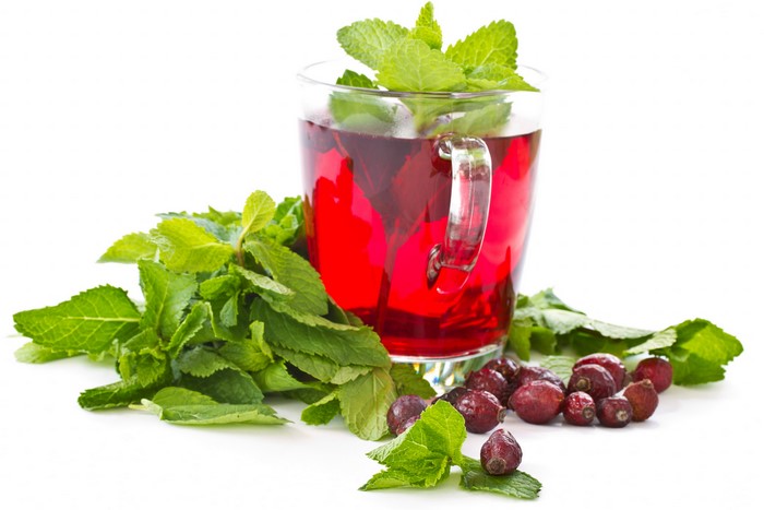 Glass cup of red tea with mint and berries
