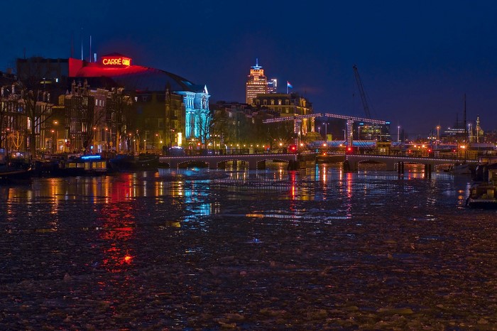 Amsterdam canal at night with Carre Theatre and bridges