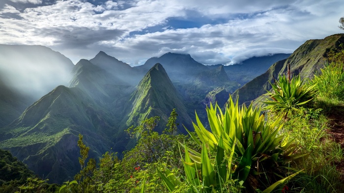 Mountain valley with dramatic clouds and green vegetation