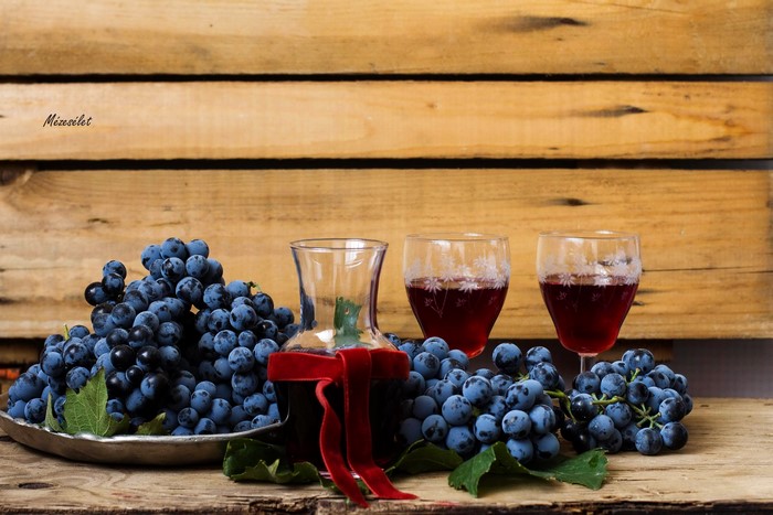 Grapes and wine in glasses with a decanter