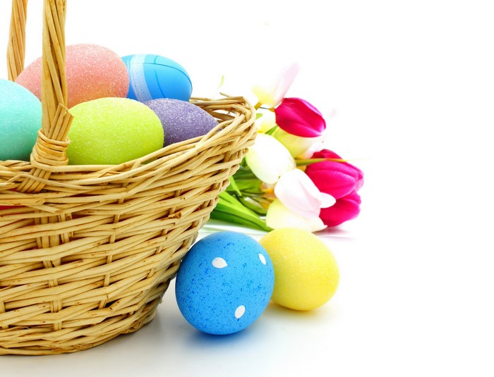 Easter basket with colorful eggs and tulips