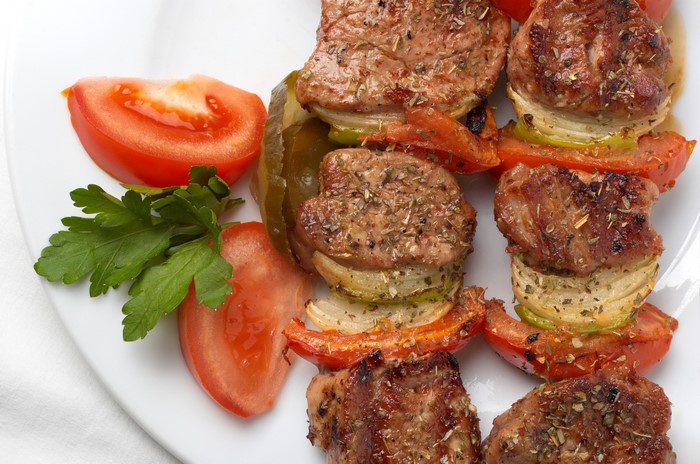 Shashlik skewers with tomatoes and parsley on a plate