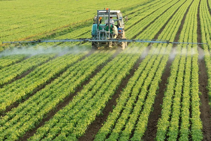 Tractor spraying crops in a field