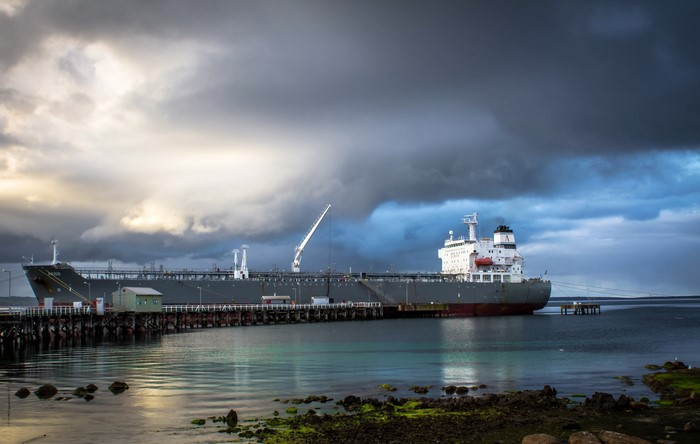 Large cargo ship docked at a pier under stormy skies