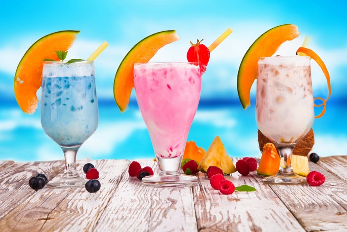 Three colorful fruit cocktails on a wooden table