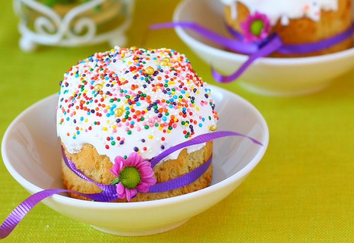 Easter Kulich pastries with colorful sprinkles and ribbon