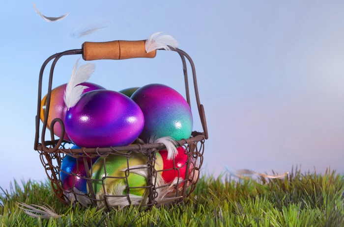 Easter eggs in a wicker basket on grass