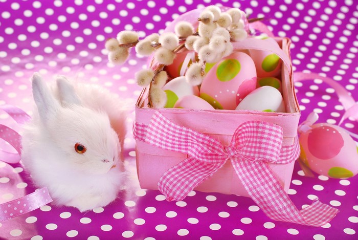 Easter bunny with decorated eggs in a pink basket