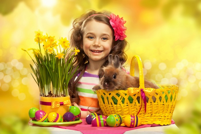 Girl with Easter bunny, daffodils, and eggs