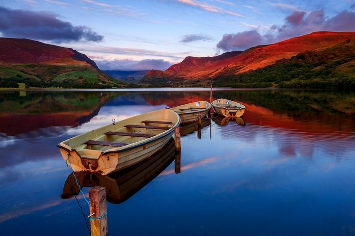 Boats on a lake with mountains at sunset