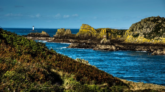 Coastline with lighthouse and rocky outcrops in Brittany, France