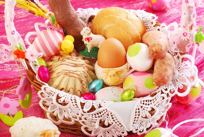 Easter basket with chocolate, eggs, bread, and sausages