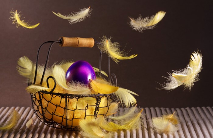 Easter basket with purple egg and yellow feathers