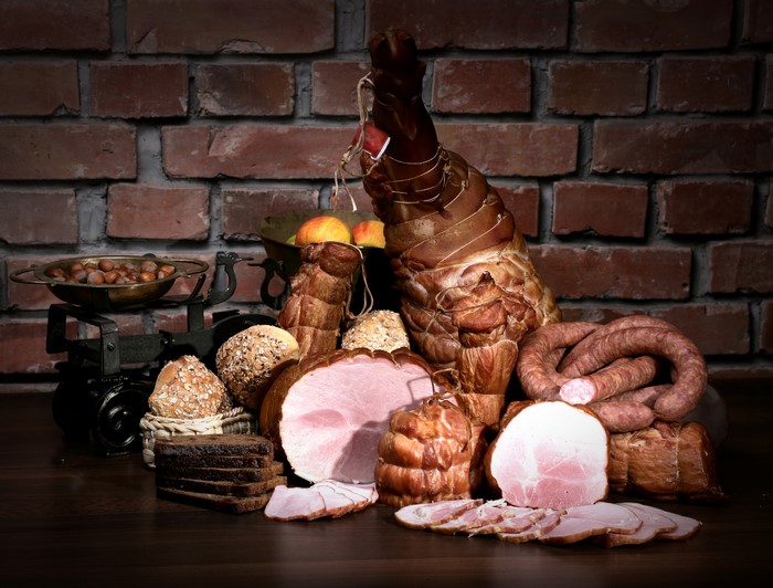 Meat products, sausage, ham, and bread on a table