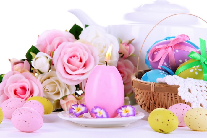 Easter still life with pink candle, roses, and decorated eggs