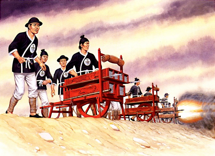 Soldiers operating a multi-barreled cannon on a sandy hill