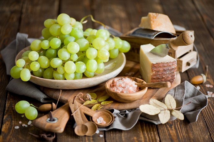 Grapes and cheese on a wooden table
