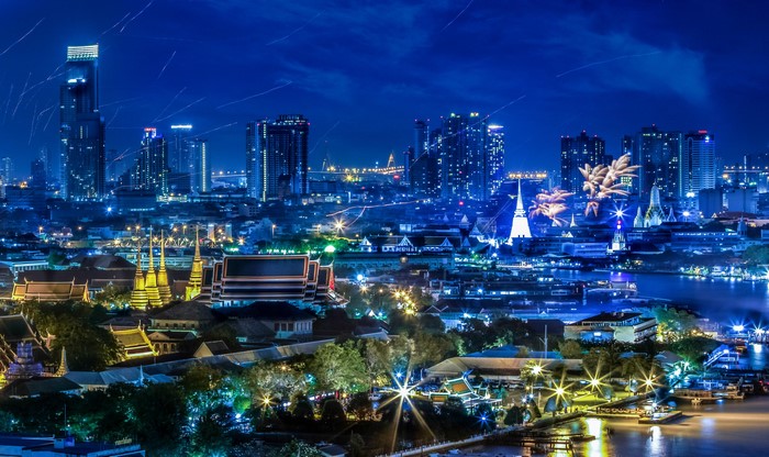 Bangkok cityscape at night with fireworks over the river