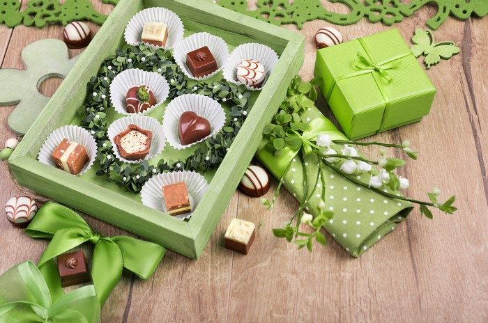 Chocolates in a green box with gift and flowers