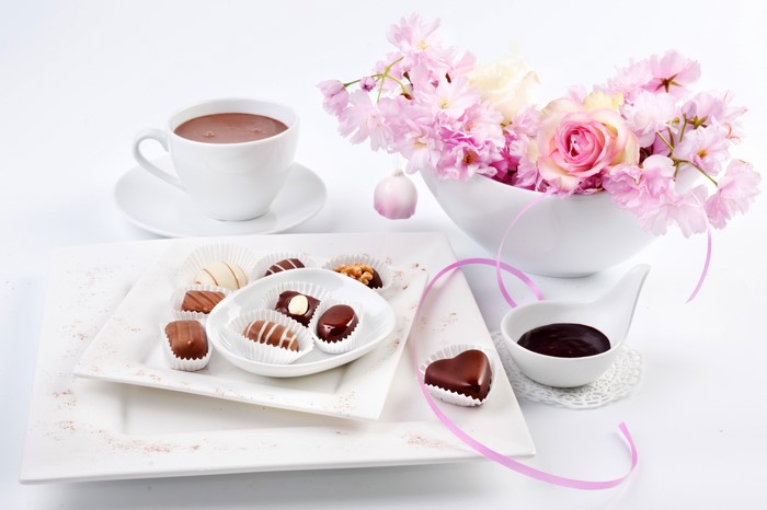 Still-life of chocolates and coffee with flowers